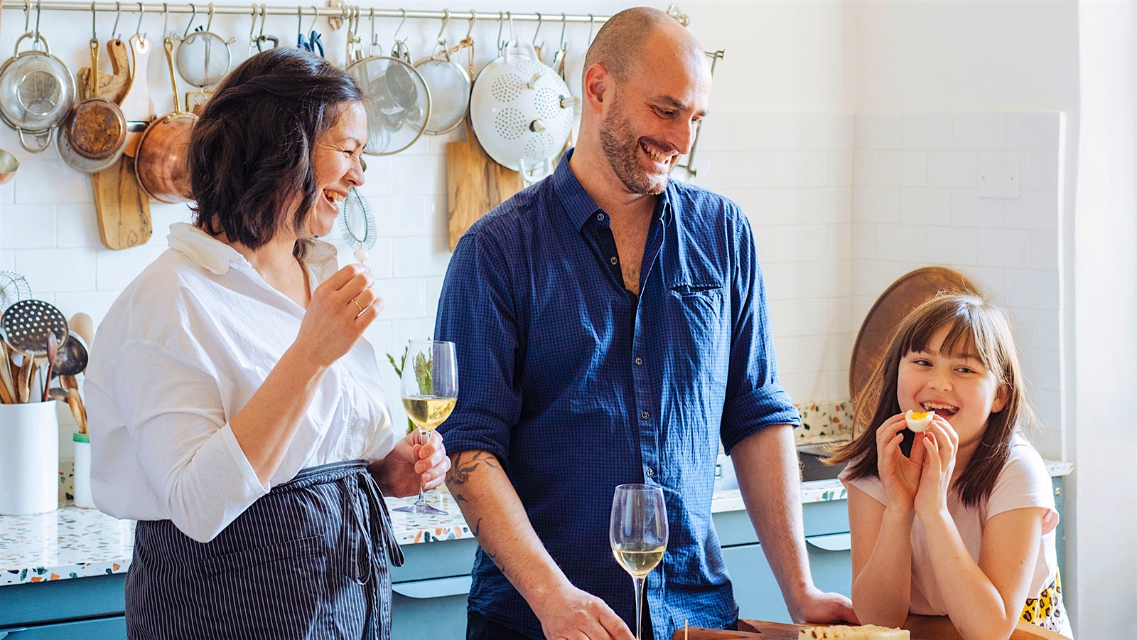 Emiko Davies drinking wine in her kitchen with her husband Marco and daughter Mariù.